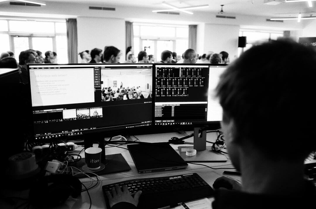 Journalist working at a desk with multiple monitors displaying news feeds