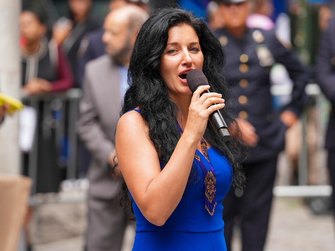 Reporter holding a microphone covering a live event outdoors